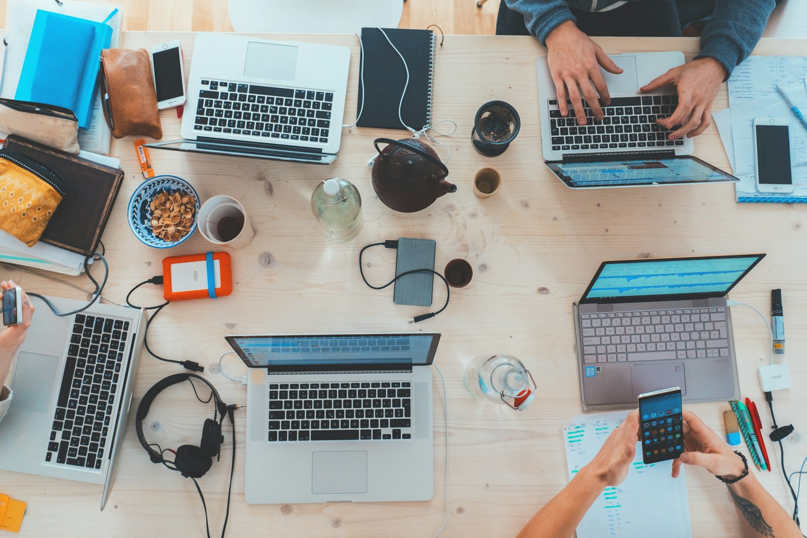 A team working across laptops on a shared table